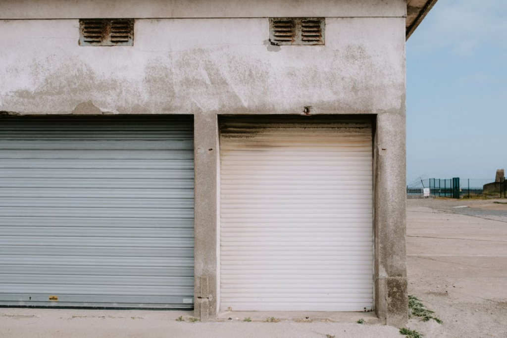 Installers replacing an old garage door with a new entry door model