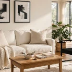 Cozy black and white living room with a white sofa, black accent chair, natural wood furniture, and a textured rug.