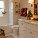 Cozy Christmas bathroom with an evergreen mirror wreath, red plaid towels, festive shower curtain, and holiday accessories.