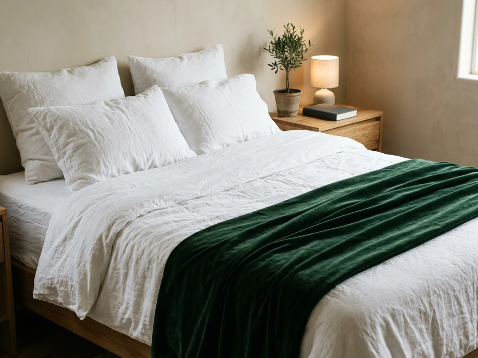 Bed with a velvet throw at the foot and a mini tree on the nightstand